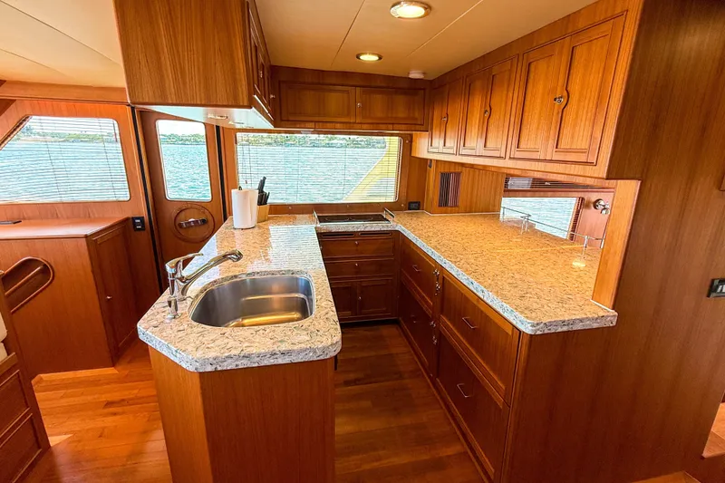 Slide: The Image of Luxurious Marlow 53E 2018 yacht kitchen with wood cabinetry and granite countertops. - 54
