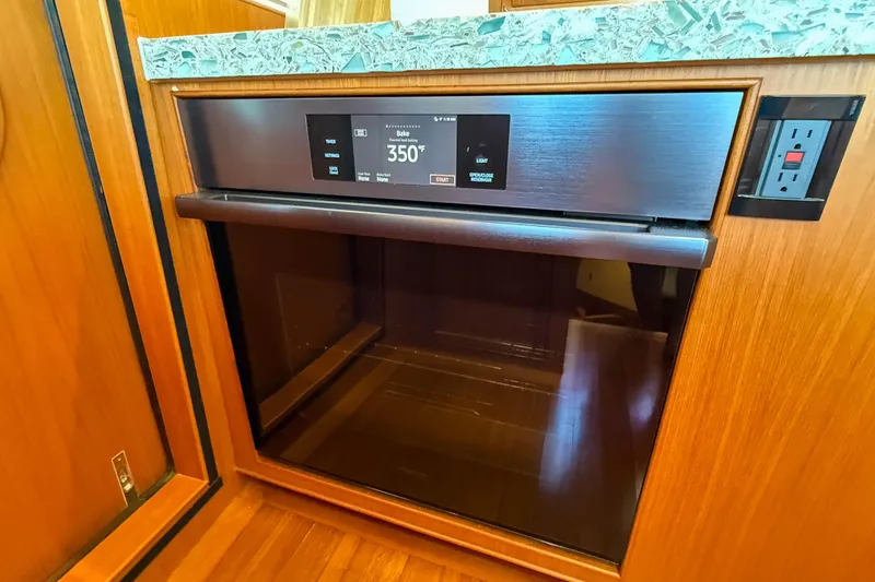 Slide: The Image of Modern oven in Marlow 53E yacht, 2018 model, set to 350°F, with wood paneling. - 58