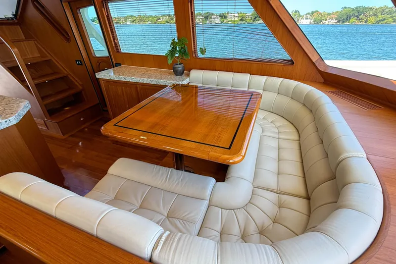 Slide: The Image of Luxurious Marlow 53E yacht interior with leather seating and wooden table, overlooking serene waters. - 63