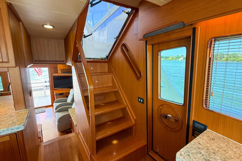 Slide: The Image of Interior of 2018 Marlow 53E yacht with wooden stairs and scenic water view. - 64