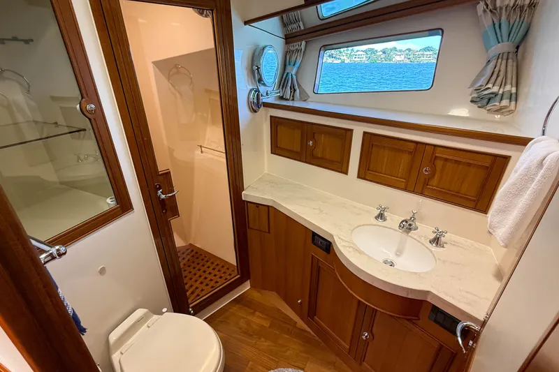 Slide: The Image of Luxurious Marlow 53E 2018 yacht bathroom with wood accents and ocean view window. - 79