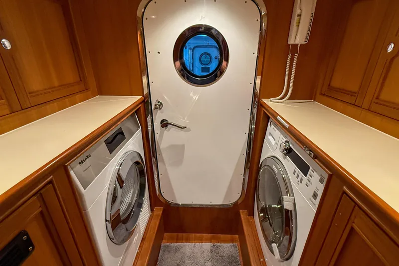 Slide: The Image of Laundry area on 2018 Marlow 53E yacht with washer, dryer, and porthole door. - 83