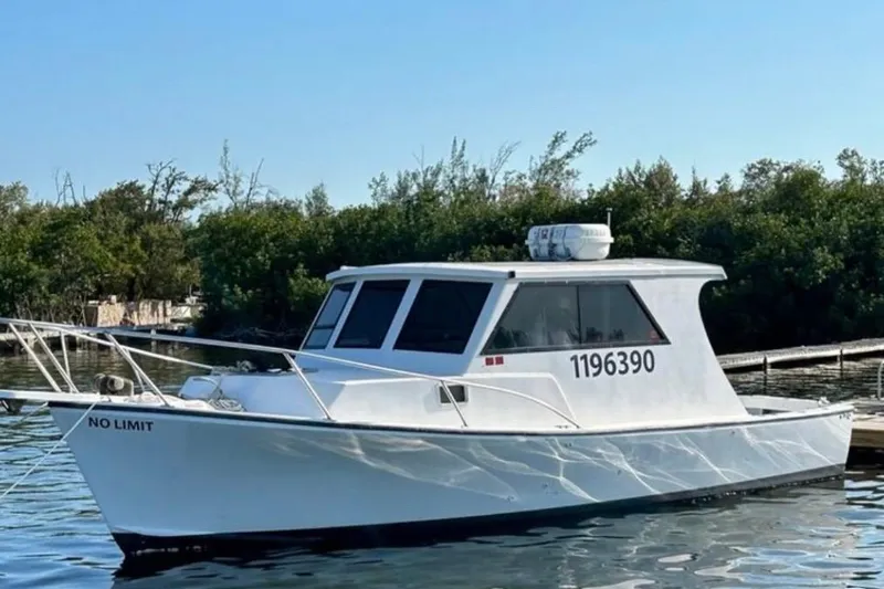Slide: The Image of 2005 Crusader 34 SF boat named "No Limit" docked on calm water. - 2