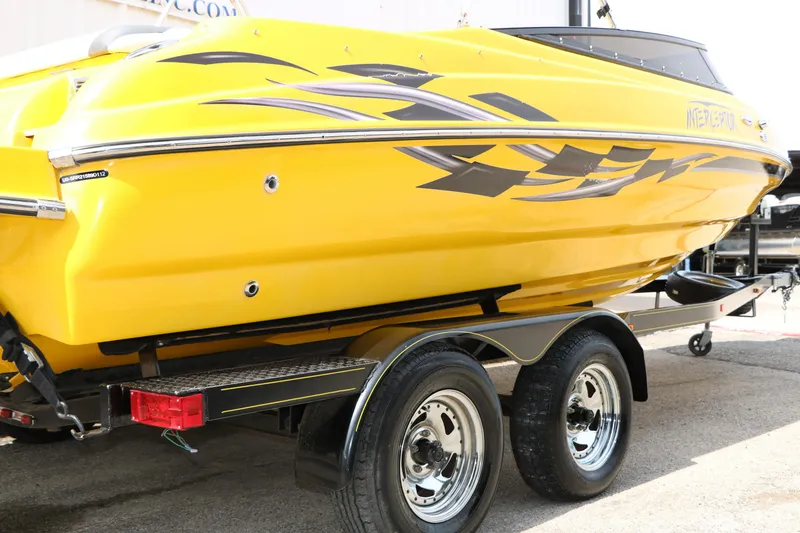 Slide: The Image of Yellow 2012 Caravelle Interceptor 232 Bow Rider boat on trailer, featuring sleek graphics. - 7