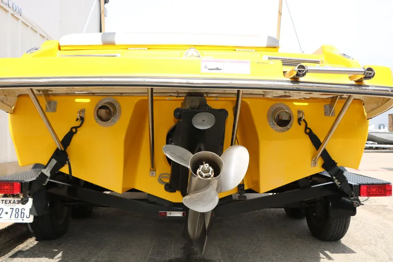 Slide: The Image of 2012 Caravelle Interceptor 232 Bow Rider, yellow hull, rear view with propeller and trailer. - 8
