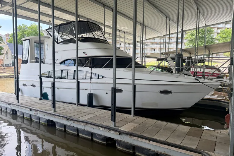 Slide: The Image of 2000 Carver 396 Motor Yacht docked in a covered marina, showcasing sleek design and spacious cabin. - 1