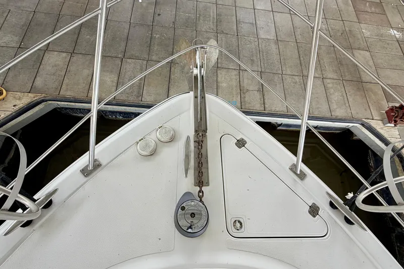 Slide: The Image of Bow view of 2000 Carver 396 Motor Yacht docked, showcasing anchor and deck details. - 15