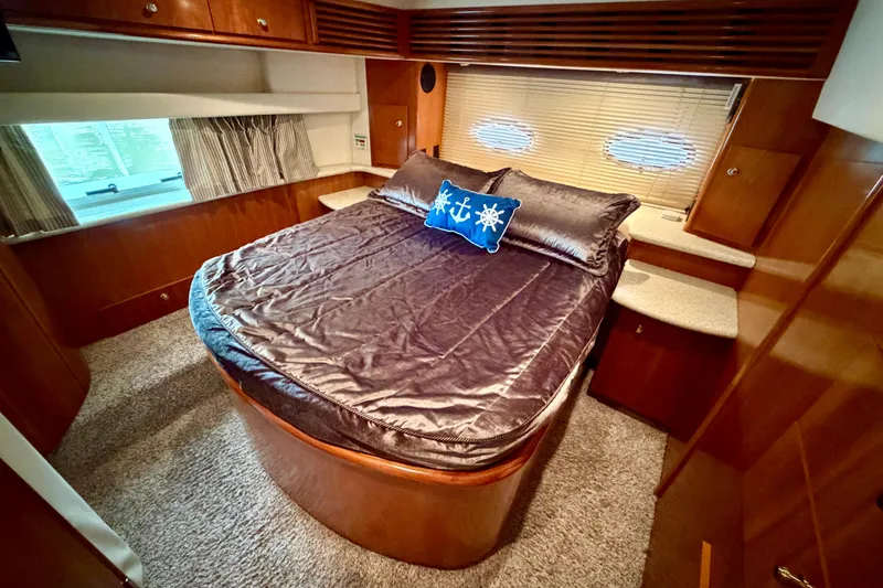 Slide: The Image of Luxurious bedroom interior of 2000 Carver 396 Motor Yacht with elegant bedding and wood finishes. - 24
