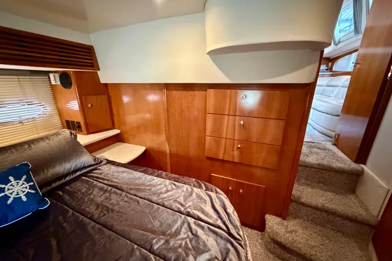 Slide: The Image of Luxurious interior of 2000 Carver 396 Motor Yacht with wood cabinetry and cozy bedding. - 25