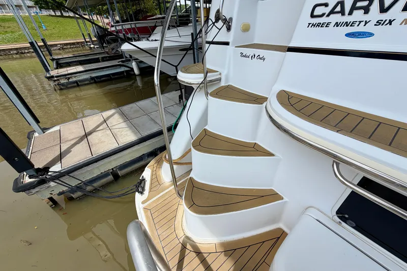 Slide: The Image of Carver 396 Motor Yacht 2000 docked, showcasing elegant teak steps and sleek design. - 3