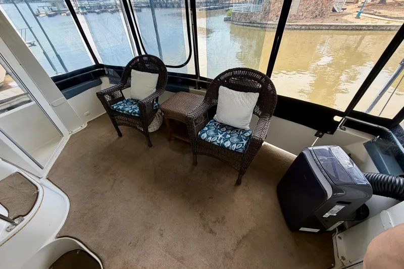 Slide: The Image of Interior of 2000 Carver 396 Motor Yacht with wicker chairs and scenic marina view. - 4