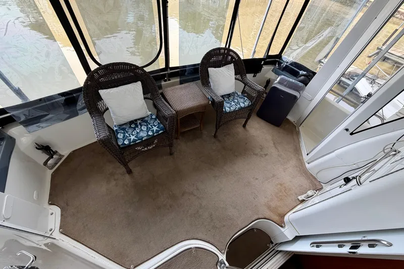 Slide: The Image of Interior of 2000 Carver 396 Motor Yacht with wicker chairs and carpeted floor. - 5