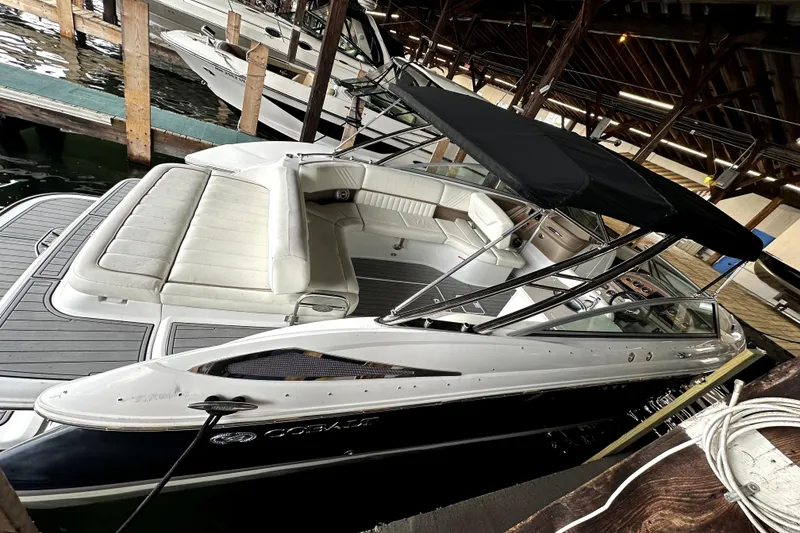 Slide: The Image of 2008 Cobalt 302 boat docked, featuring white seating and a black canopy. - 2