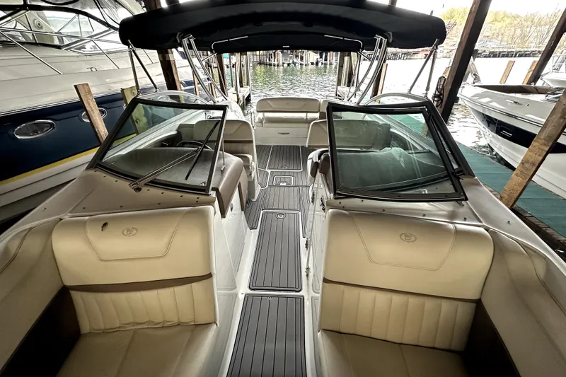 Slide: The Image of 2008 Cobalt 302 boat interior with beige seating and open windshield, docked in a marina. - 3