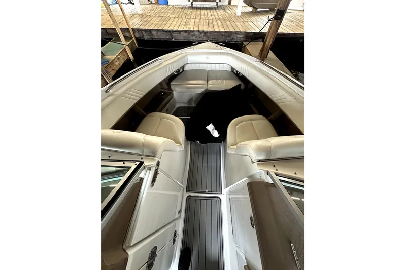 Slide: The Image of 2008 Cobalt 302 boat interior with beige seating and gray flooring, docked at a marina. - 8