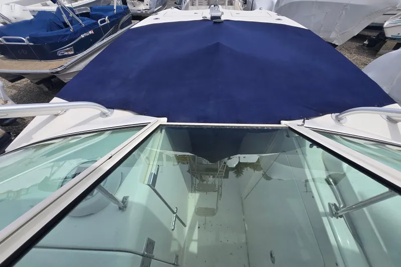 Slide: The Image of 2015 World Cat 295 DC boat with blue cover, docked among other boats. - 11
