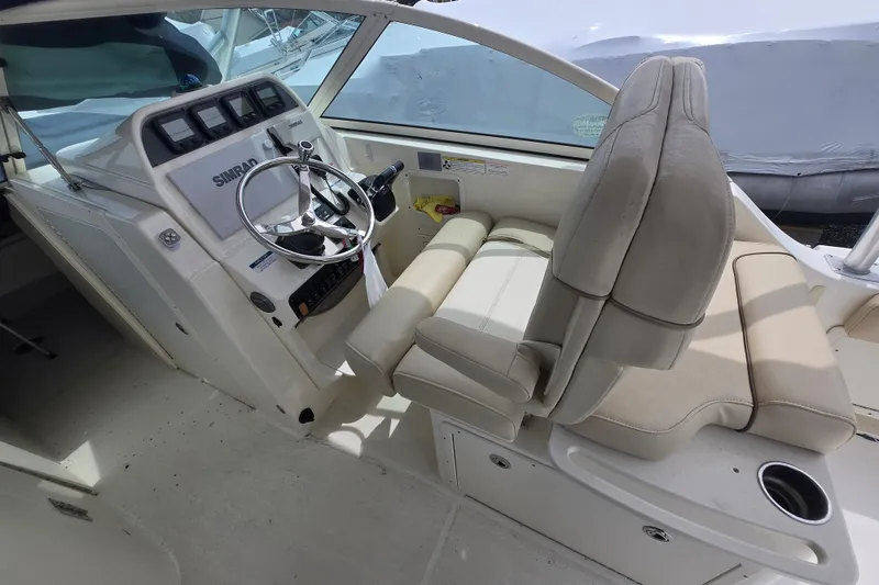 Slide: The Image of 2015 World Cat 295 DC boat interior with steering wheel and seating area. - 12