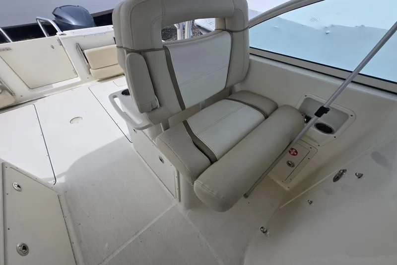Slide: The Image of 2015 World Cat 295 DC boat interior with beige seating and storage compartments. - 15