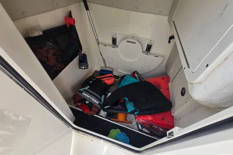Slide: The Image of Storage compartment of a 2015 World Cat 295 DC boat with safety gear and equipment. - 18