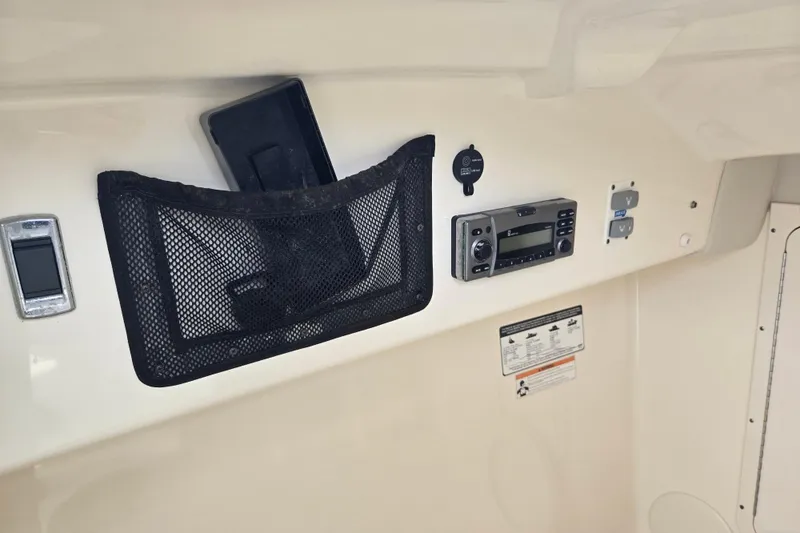 Slide: The Image of Control panel of a 2015 World Cat 295 DC boat with mesh storage and radio. - 33