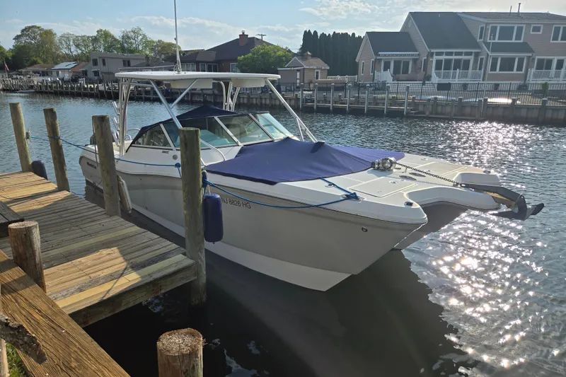 Slide: The Image of 2015 World Cat 295 DC boat docked by waterfront homes. - 4
