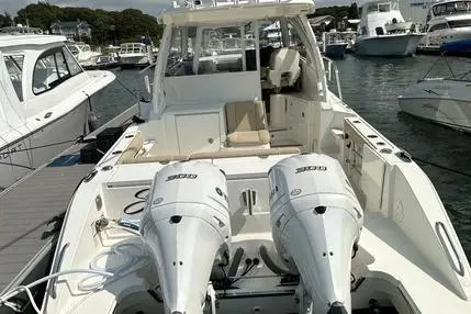 Slide: The Image of 2020 Pursuit OS 325 Offshore boat with dual engines docked in a marina. - 2