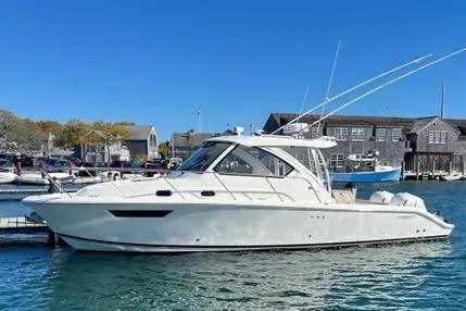 The Image of 2020 Pursuit OS 325 Offshore boat docked in a marina under clear blue skies. - 4