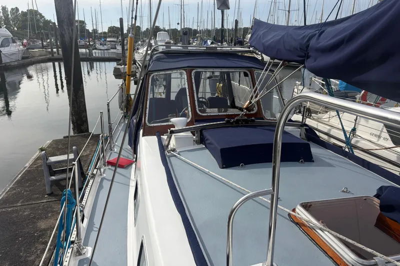 Slide: The Image of 1977 Folkes Full Keel Offshore Cutter docked in a marina, showcasing deck and cabin details. - 16