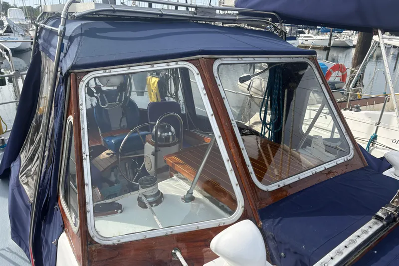 Slide: The Image of 1977 Folkes Full Keel Offshore Cutter cockpit with blue canopy and wooden interior. - 18