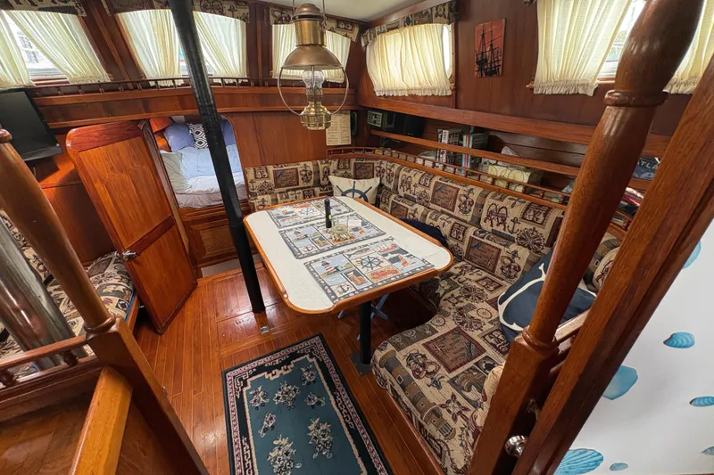 Slide: The Image of Interior of 1977 Folkes Full Keel Offshore Cutter with cozy seating and nautical decor. - 35