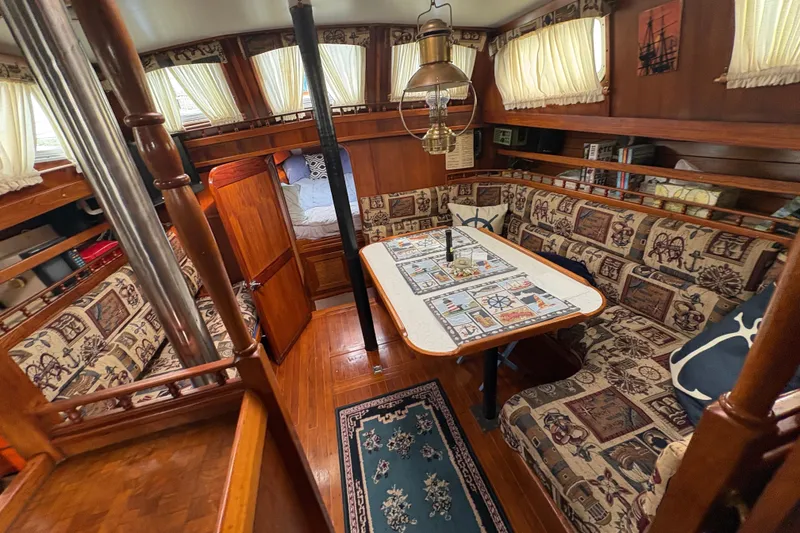 Slide: The Image of 1977 Folkes Full Keel Offshore Cutter interior with nautical-themed decor and wooden furnishings. - 36