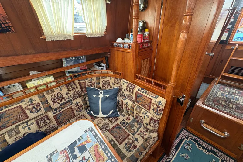 Slide: The Image of Cozy 1977 Folkes Full Keel Offshore Cutter interior with nautical-themed decor and wooden furnishings. - 40