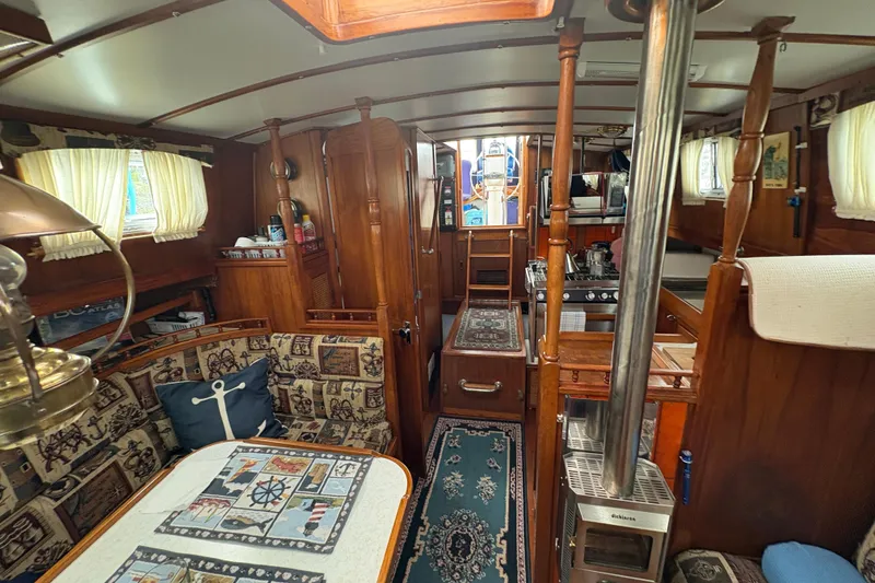 Slide: The Image of Interior of a 1977 Folkes Full Keel Offshore Cutter, featuring cozy wood paneling and nautical decor. - 47