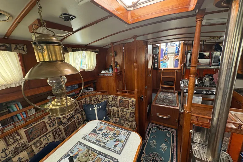 Slide: The Image of Interior of a 1977 Folkes Full Keel Offshore Cutter, featuring cozy wooden furnishings and nautical decor. - 48