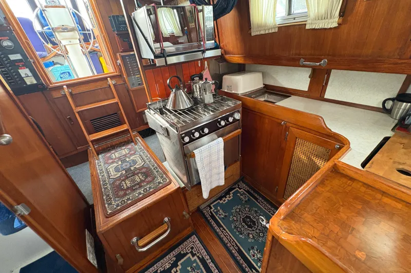 Slide: The Image of Cozy 1977 Folkes Full Keel Offshore Cutter galley with wood cabinetry and nautical decor. - 49