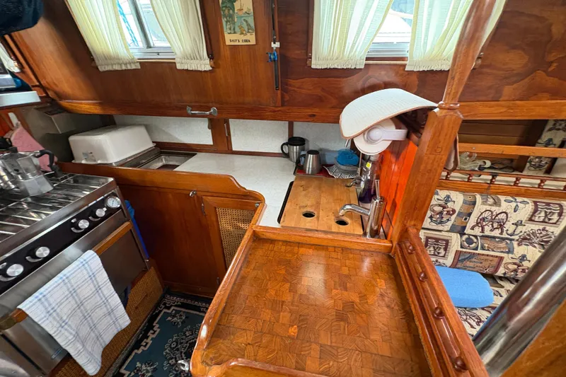 Slide: The Image of 1977 Folkes Full Keel Offshore Cutter interior with wooden cabinetry and nautical-themed decor. - 51