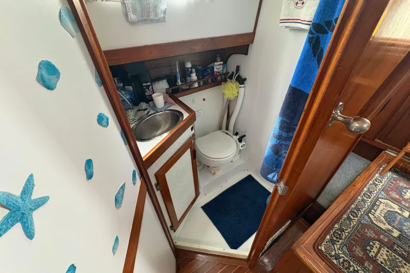 Slide: The Image of Compact bathroom in 1977 Folkes Full Keel Offshore Cutter sailboat, featuring sink and toilet. - 55