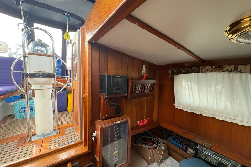 Slide: The Image of Interior of a 1977 Folkes Full Keel Offshore Cutter, featuring wooden paneling and nautical equipment. - 57