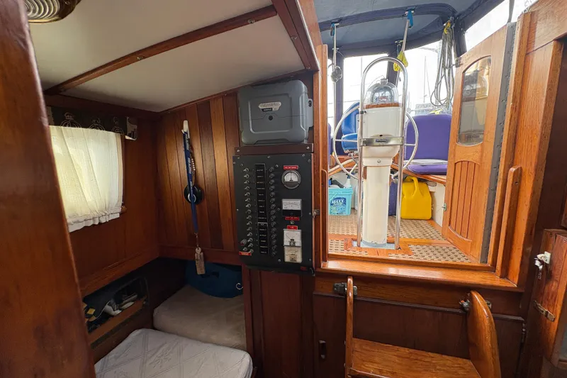 Slide: The Image of Interior of 1977 Folkes Full Keel Offshore Cutter, featuring wooden paneling and navigation equipment. - 58