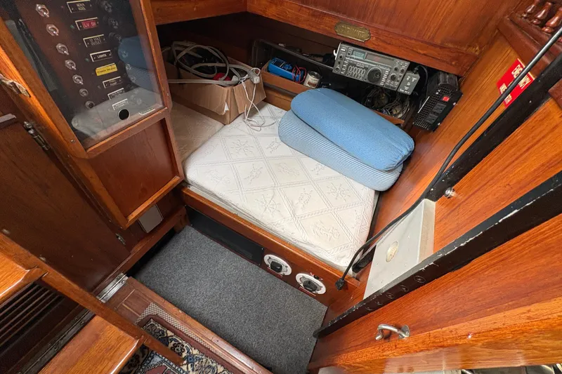 Slide: The Image of 1977 Folkes Full Keel Offshore Cutter cabin interior with radio equipment and cushioned seating. - 61