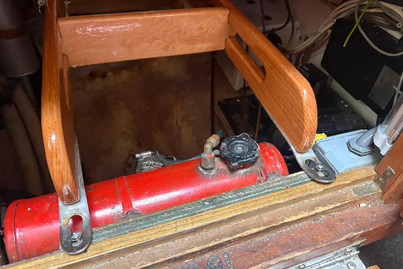Slide: The Image of Engine compartment of a 1977 Folkes Full Keel Offshore Cutter with red machinery and wooden framing. - 69