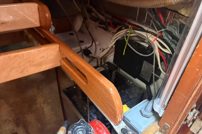 Slide: The Image of Interior view of a 1977 Folkes Full Keel Offshore Cutter, showcasing wiring and wooden cabinetry. - 70