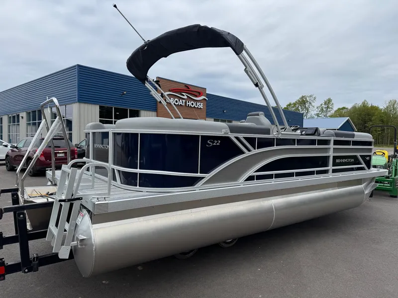 Slide: The Image of 2026 Bennington 22SSR pontoon boat parked outside a blue building. - 22