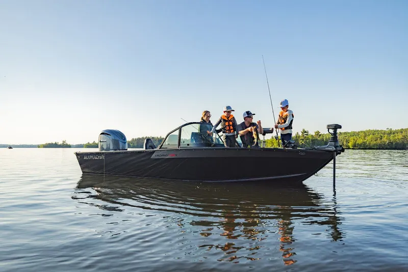 Slide: The Image of 2026 Alumacraft Trophy 195X Sport boat on a calm lake. - 19