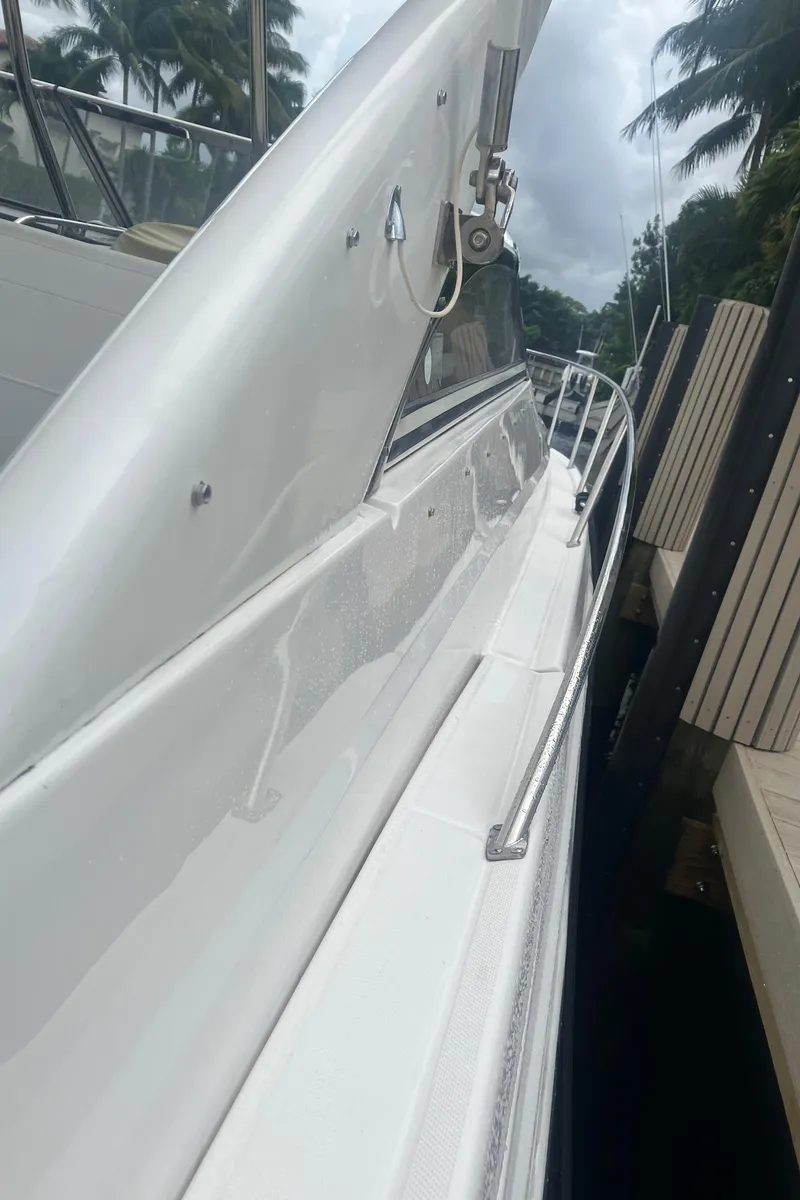 Slide: The Image of 2007 Regal 3760 Commodore yacht docked beside a wooden pier, surrounded by palm trees. - 10