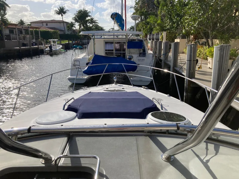 Slide: The Image of 2007 Regal 3760 Commodore yacht docked in a sunny marina, surrounded by palm trees. - 12