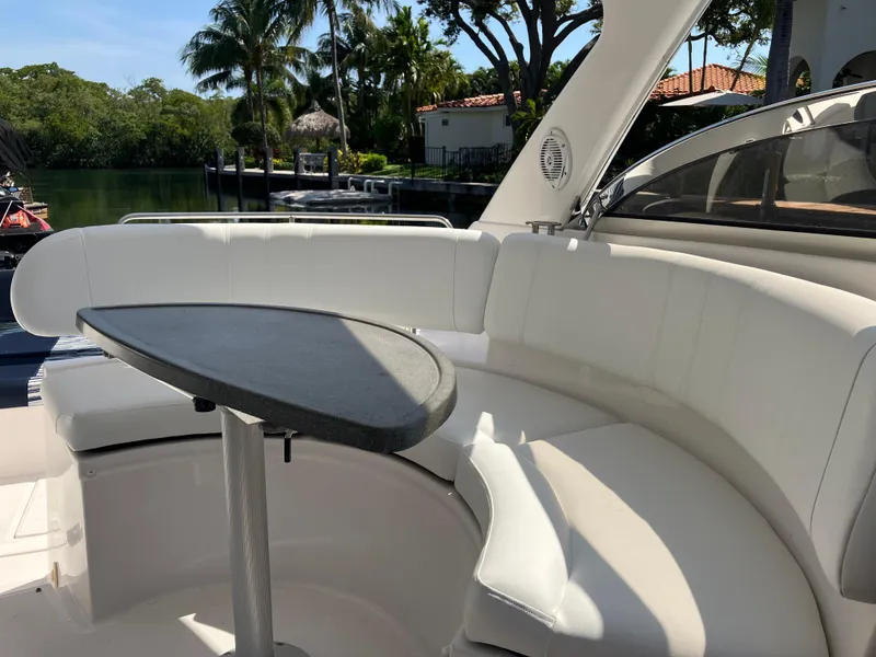 Slide: The Image of 2007 Regal 3760 Commodore yacht with white seating and table, docked near lush greenery. - 17