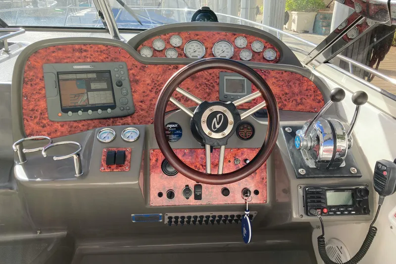 Slide: The Image of 2007 Regal 3760 Commodore boat dashboard with steering wheel and navigation controls. - 22