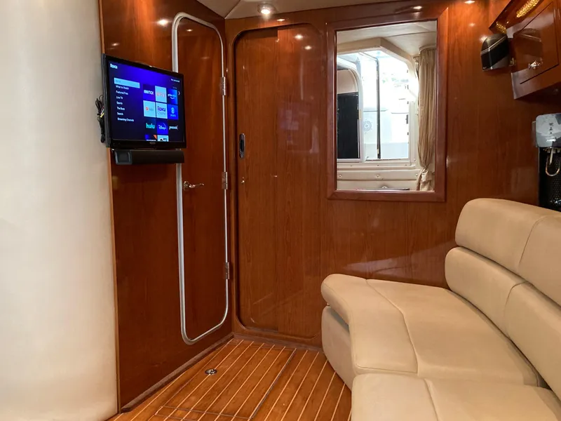 Slide: The Image of Interior of 2007 Regal 3760 Commodore yacht with TV and beige seating. - 32
