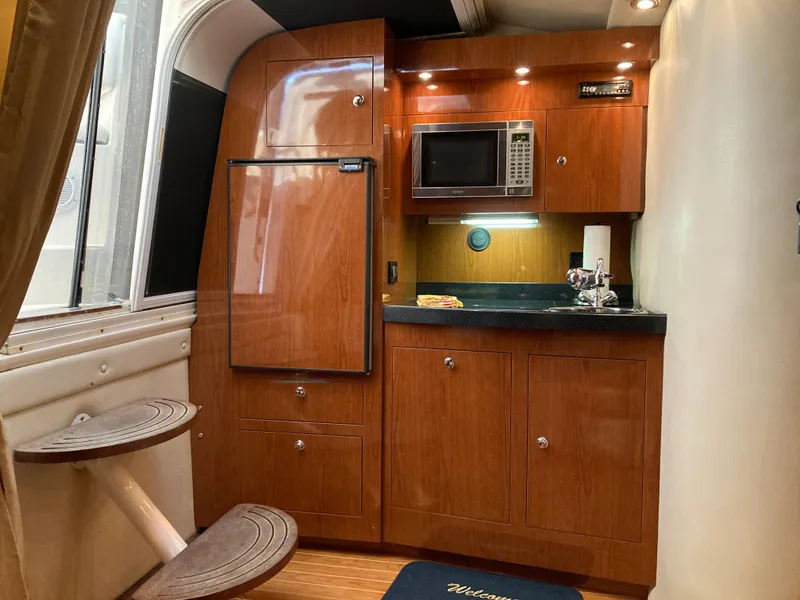 Slide: The Image of 2007 Regal 3760 Commodore yacht interior with kitchenette, featuring wood cabinetry and modern appliances. - 40